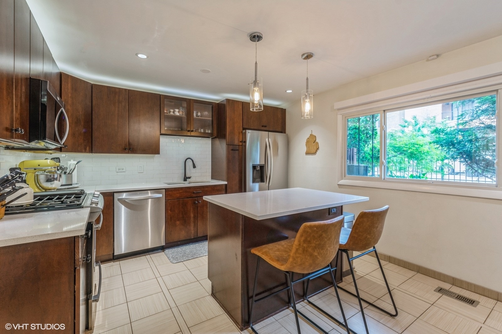 1045 West Altgeld Street, Unit A Chicago, IL 60614 - Photo 6 of 17 a kitchen with kitchen island granite countertop wooden cabinets a stove a sink and a refrigerator