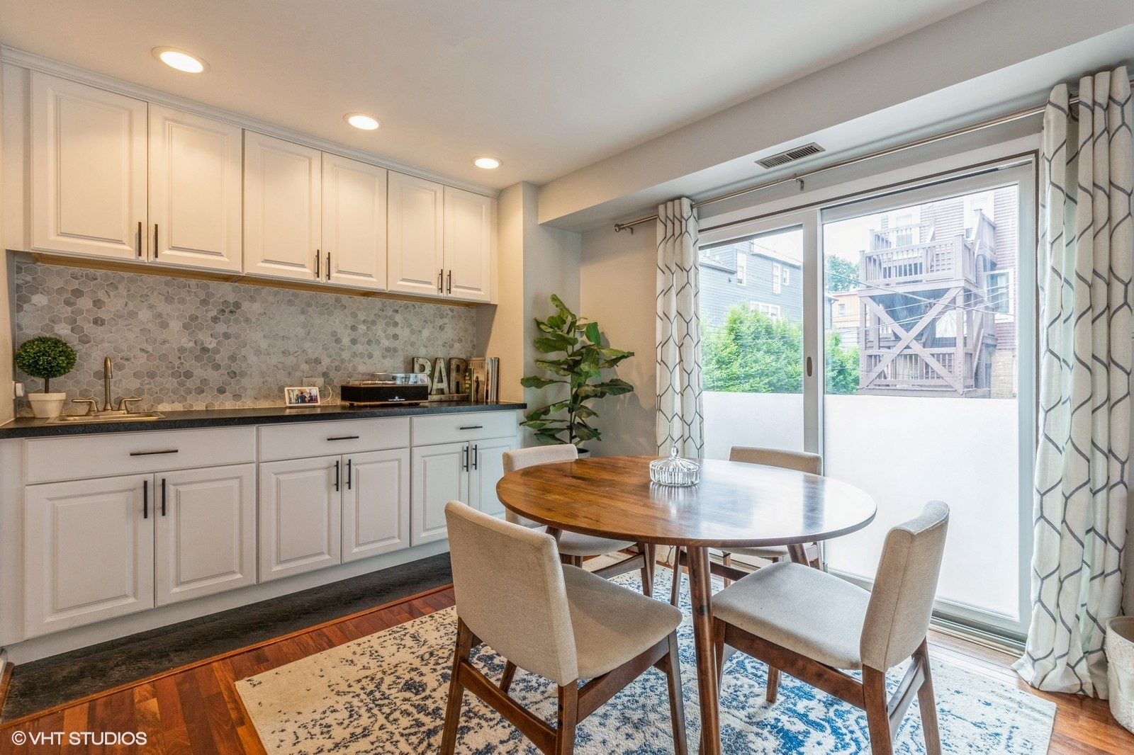 1045 West Altgeld Street, Unit A Chicago, IL 60614 - Photo 9 of 17 a kitchen with granite countertop a table chairs sink and cabinets