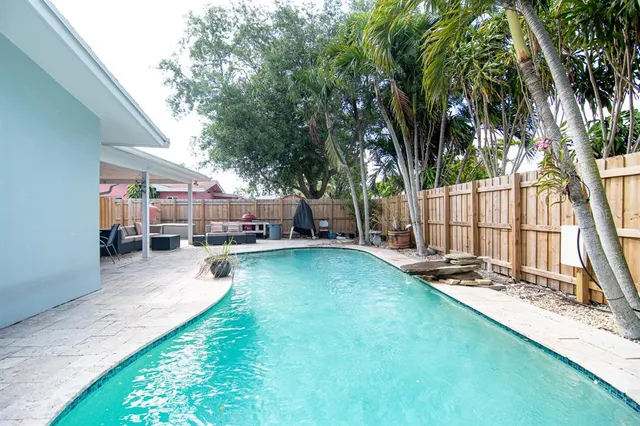 a view of backyard with swimming pool and sitting area