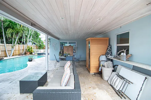 a living room with patio furniture and a floor to ceiling window