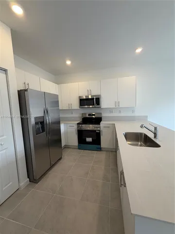 a kitchen with a refrigerator sink and microwave