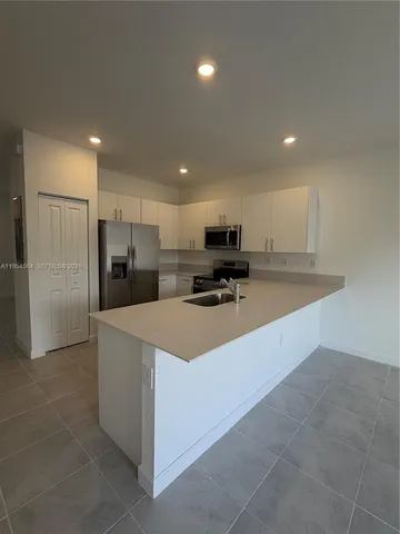a kitchen with stainless steel appliances a refrigerator sink and microwave