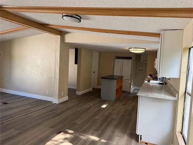 a view of a hallway with wooden floor and a living room