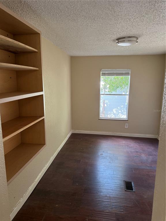 7229 Allyson Street Port Richey, FL 34668 - Photo 6 of 11 a view of an empty room with wooden floor and a window