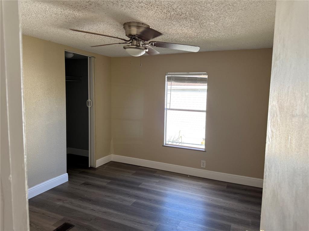 7229 Allyson Street Port Richey, FL 34668 - Photo 8 of 11 an empty room with wooden floor closet and windows