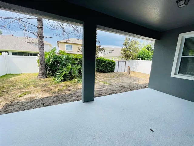 a view of a porch with a floor to ceiling window and wooden floor
