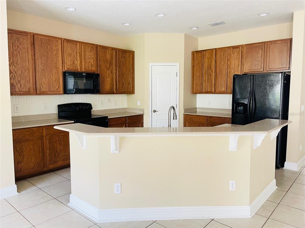 13645 Riggs Way Windermere, FL 34786 - Photo 5 of 12 a kitchen with stainless steel appliances wooden cabinets and a refrigerator