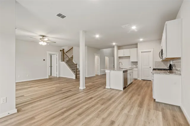 a view of kitchen with kitchen island sink stove and wooden floor