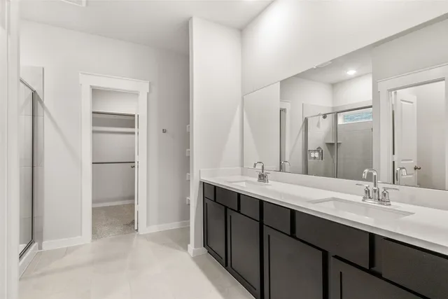 a bathroom with a double vanity sink mirror and shower