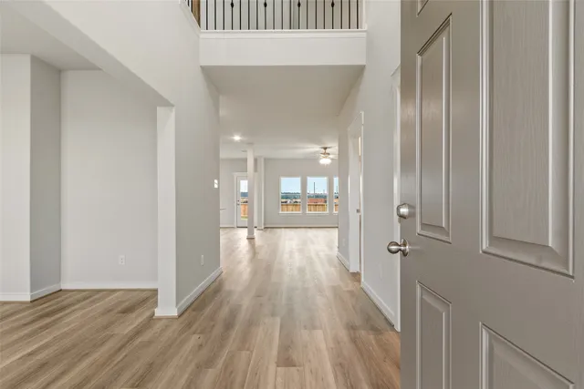 a view of a hallway with wooden floor and staircase