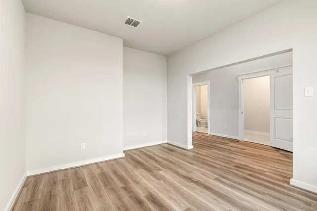 a view of an empty room with wooden floor