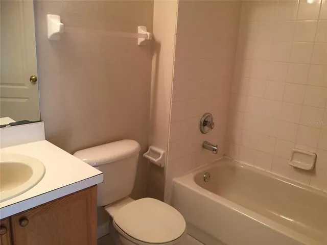 a white toilet sitting next to a bath tub