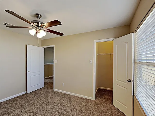 a view of a livingroom with a ceiling fan and a window