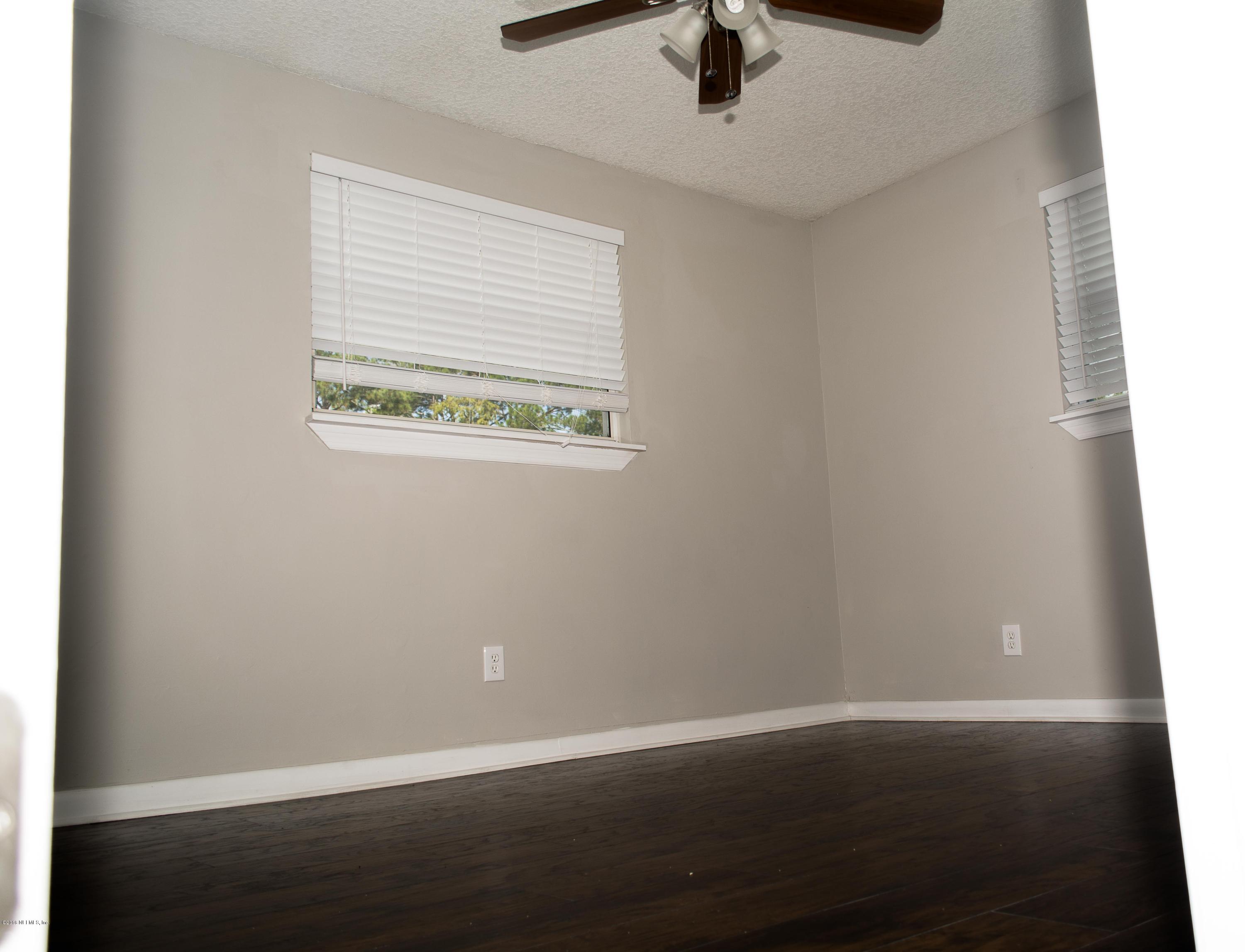 4133 Dayrl Road Jacksonville, FL 32207 - Photo 13 of 21 an empty room with a window and wooden floor
