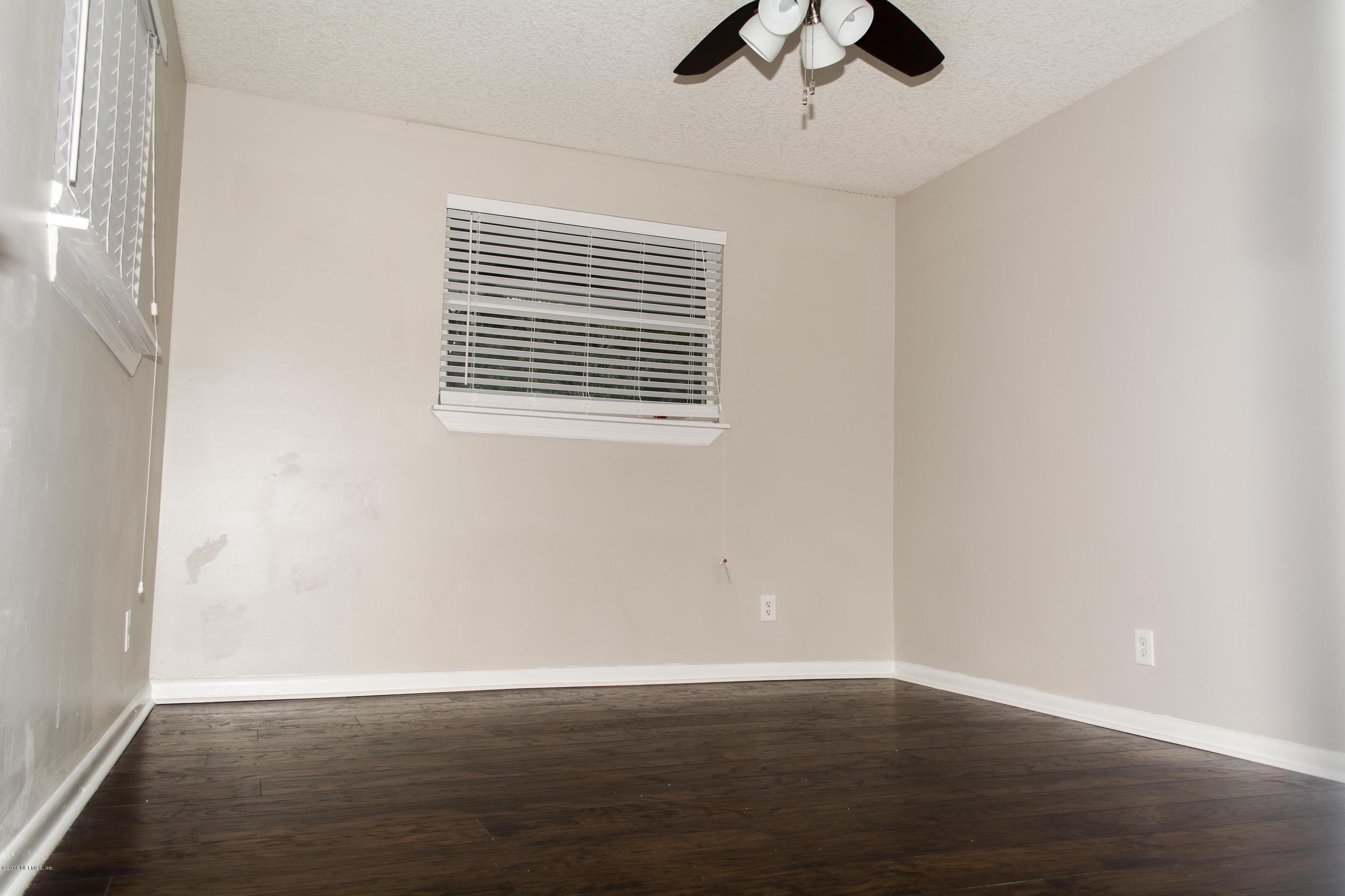 4133 Dayrl Road Jacksonville, FL 32207 - Photo 14 of 21 a view of an empty room with window and wooden floor