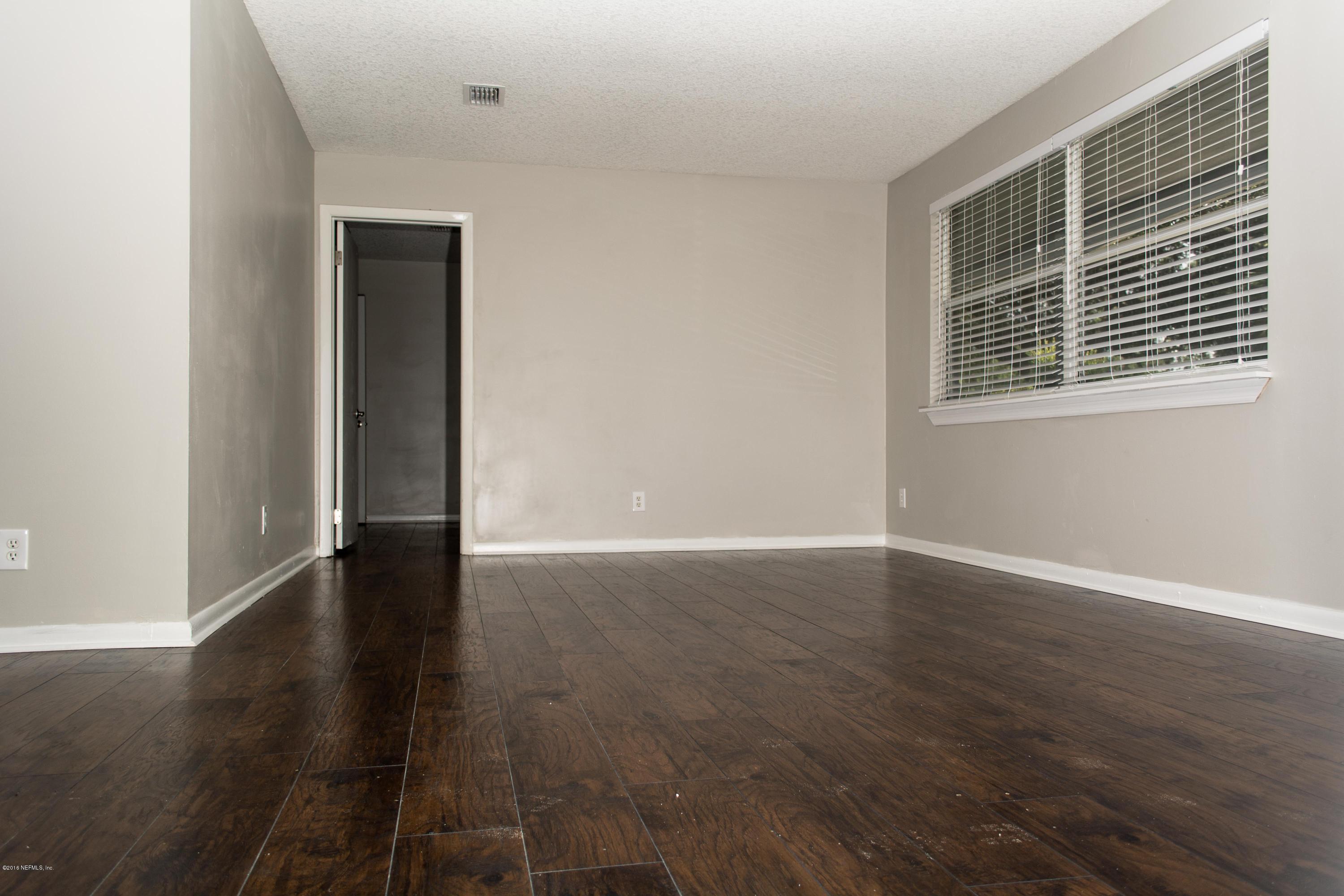 4133 Dayrl Road Jacksonville, FL 32207 - Photo 4 of 21 a view of an empty room with wooden floor and a window