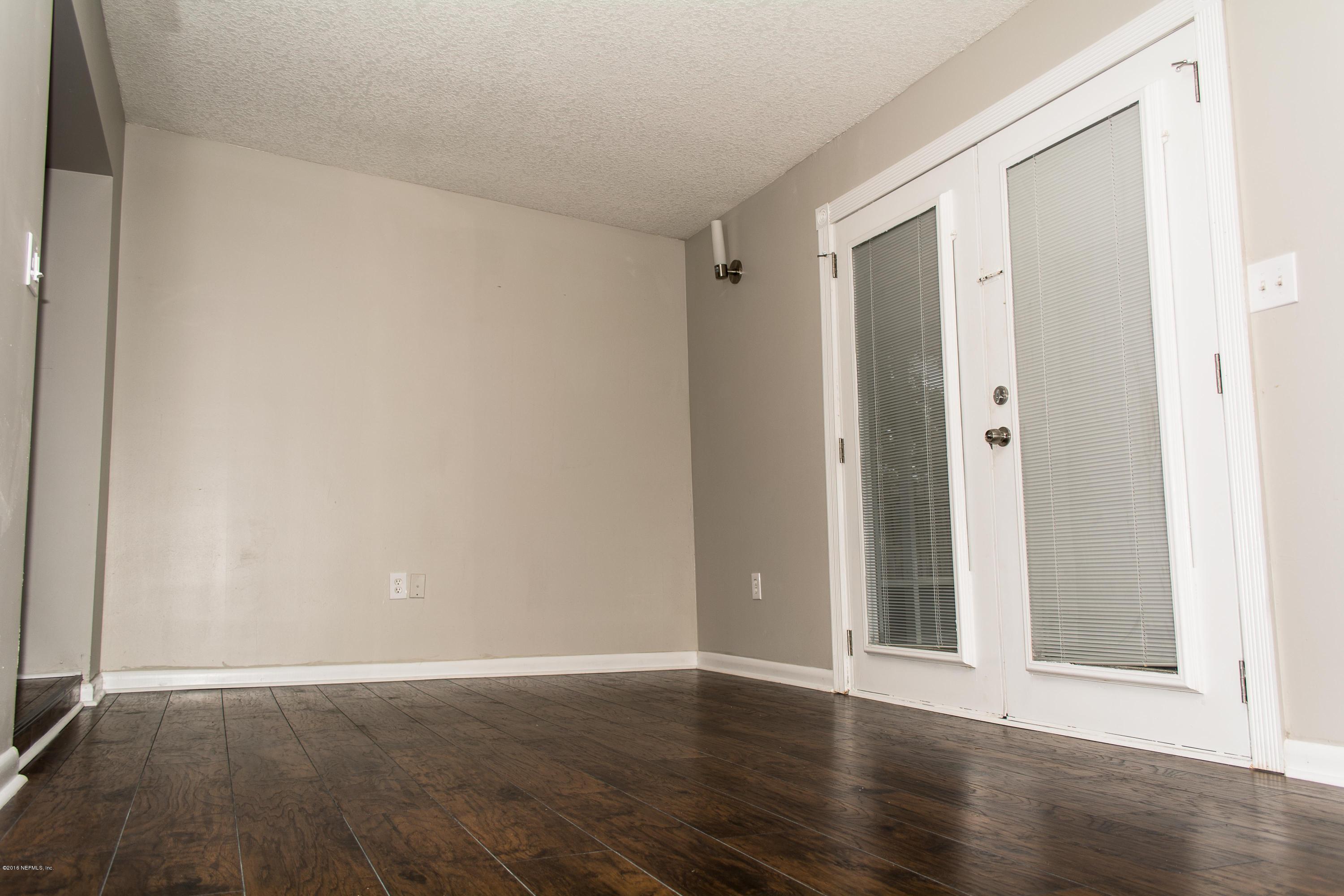 4133 Dayrl Road Jacksonville, FL 32207 - Photo 5 of 21 a view of an empty room with wooden floor and a window