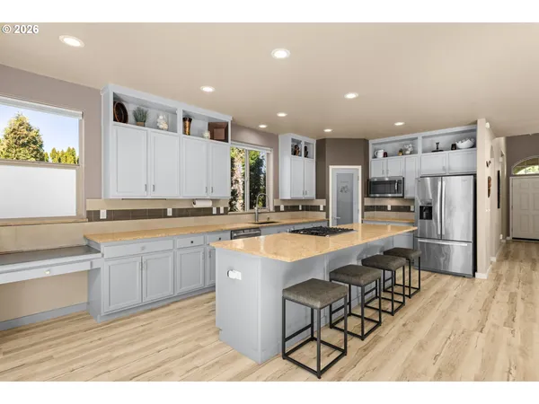 a kitchen with stainless steel appliances granite countertop a sink a stove a refrigerator and island