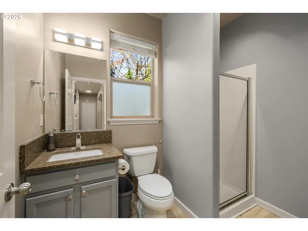 a bathroom with a granite countertop toilet sink and mirror