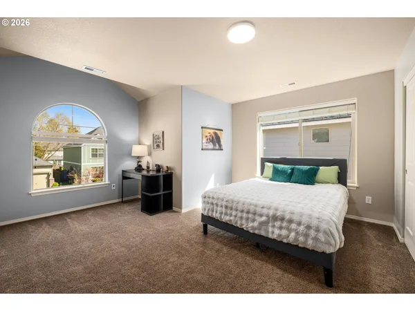 a bedroom with a large bed and a window