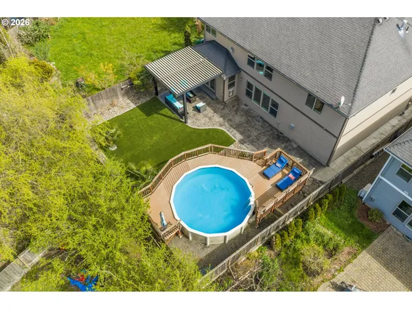 a aerial view of a house with swimming pool and large trees