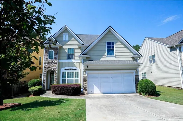 a front view of a house with a yard and garage