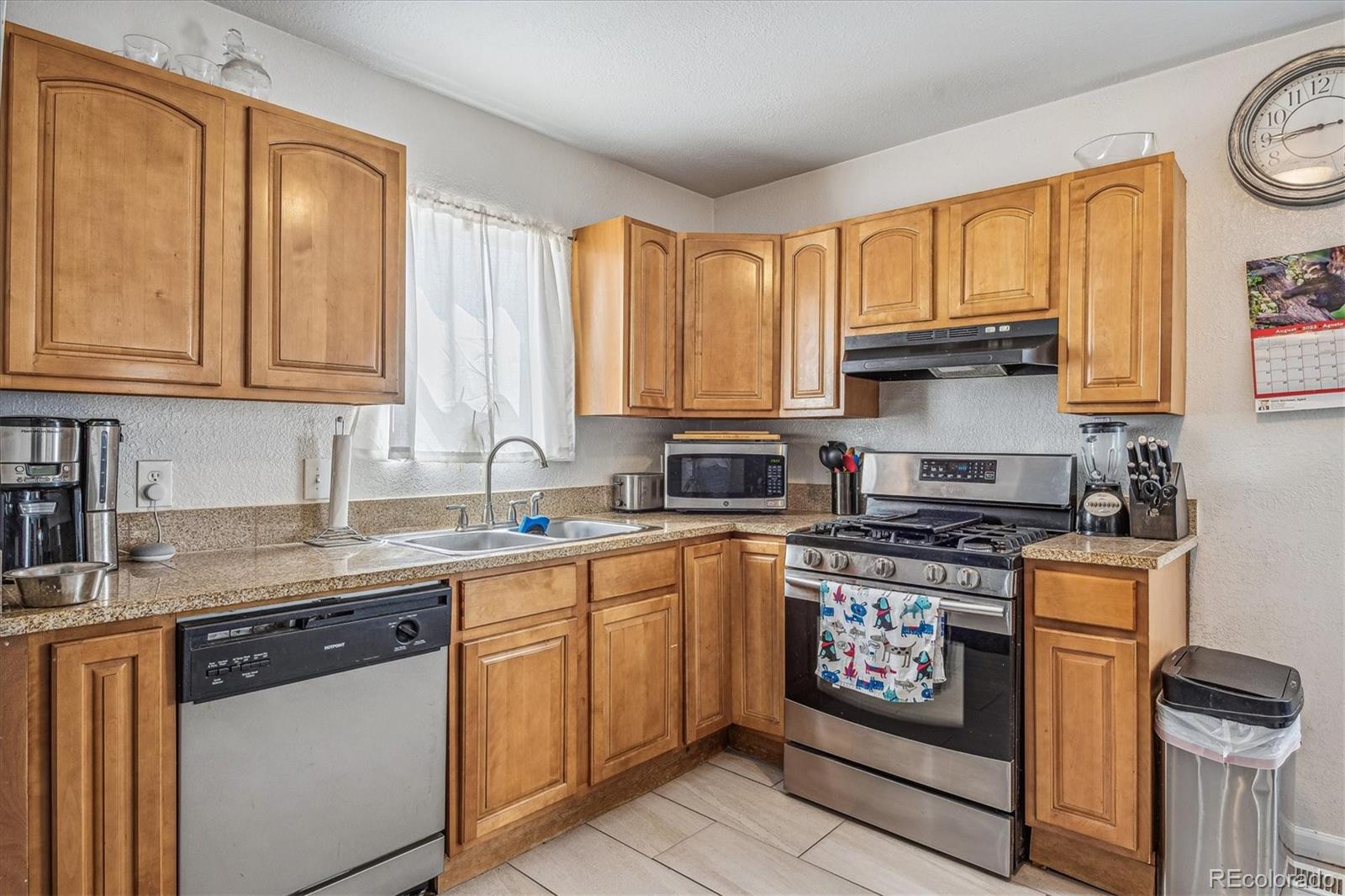631 South Raleigh Street Denver, CO 80219 - Photo 6 of 15 a kitchen with stainless steel appliances granite countertop a stove a sink and a microwave