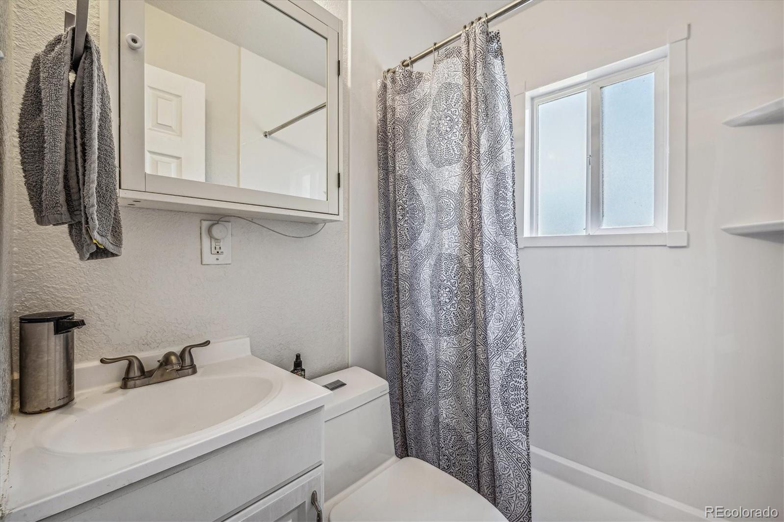 631 South Raleigh Street Denver, CO 80219 - Photo 10 of 15 a bathroom with a sink a toilet and shower