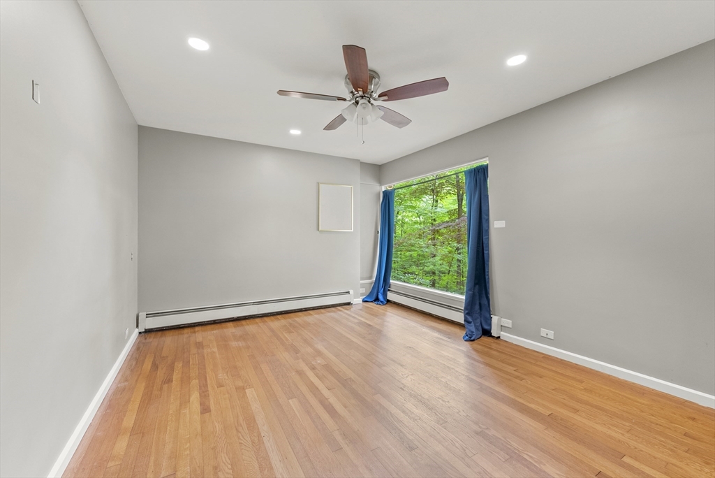 505 Mountain Road Wilbraham, MA 01095 - Photo 21 of 35 an empty room with wooden floor chandelier fan and windows