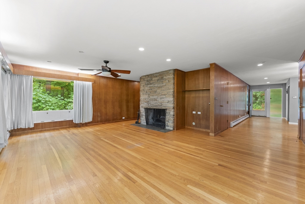 505 Mountain Road Wilbraham, MA 01095 - Photo 4 of 35 an empty room with wooden floor fireplace and windows