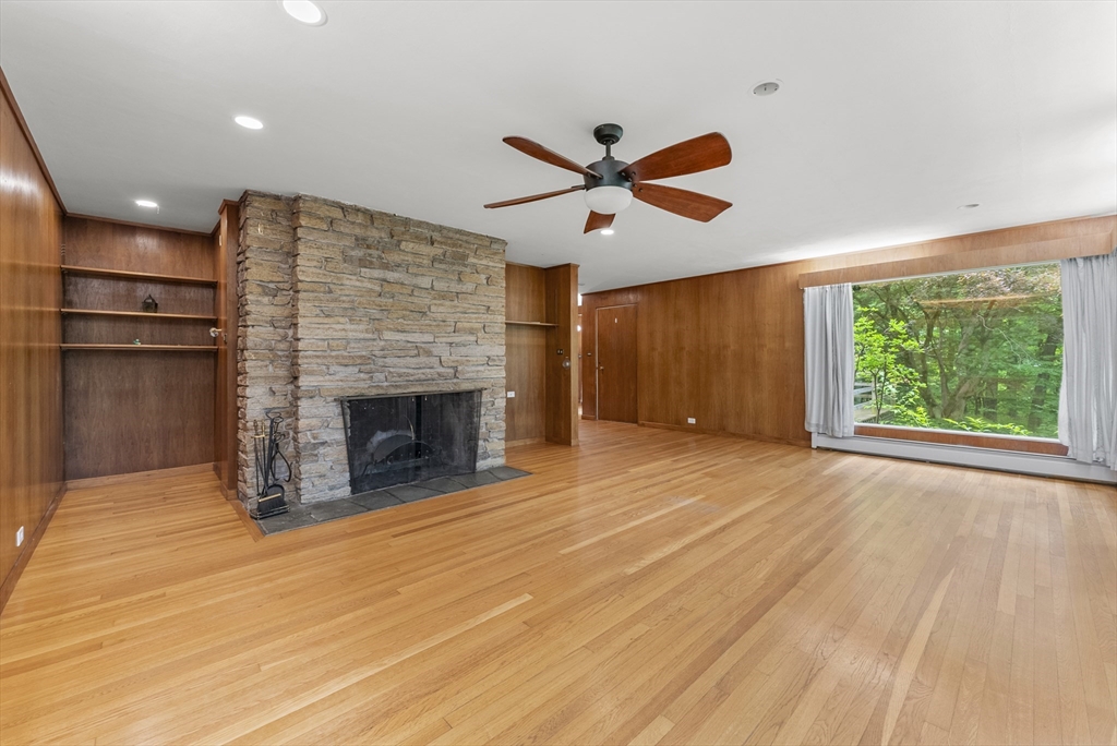 505 Mountain Road Wilbraham, MA 01095 - Photo 5 of 35 an empty room with windows fireplace and wooden floor