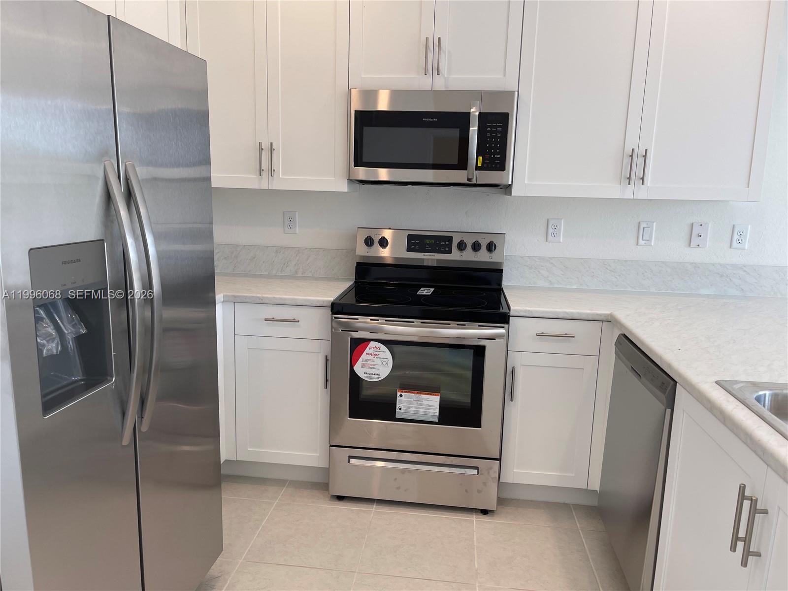 13262 Southwest 287th Terrace Homestead, FL 33033 - Photo 23 of 33 a kitchen with stainless steel appliances a stove a microwave and a sink