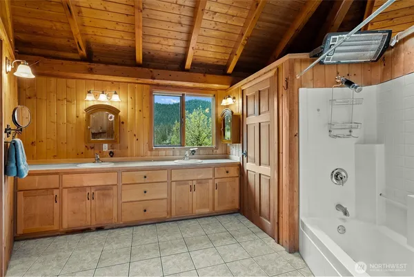 a spacious bathroom with a granite countertop sink mirror and bathtub