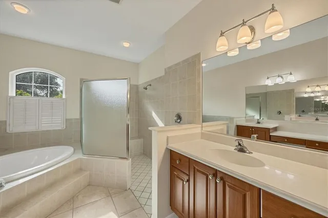 a bathroom with a double vanity sink a mirror and a bathtub