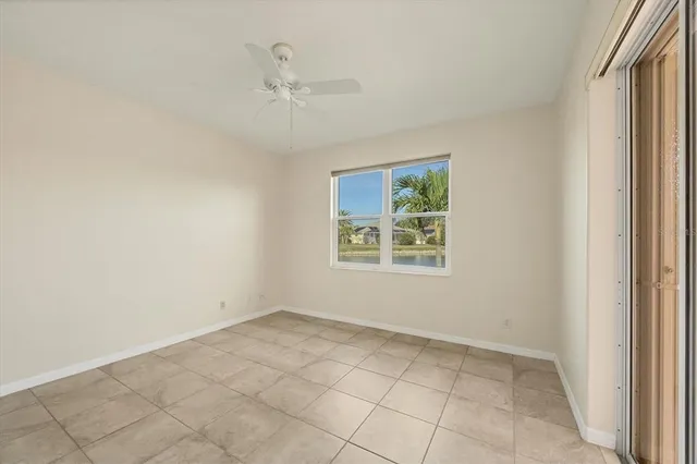 an empty room with a window and a ceiling fan
