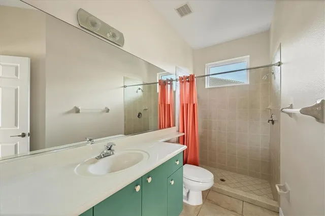 a bathroom with a granite countertop sink a toilet and a mirror