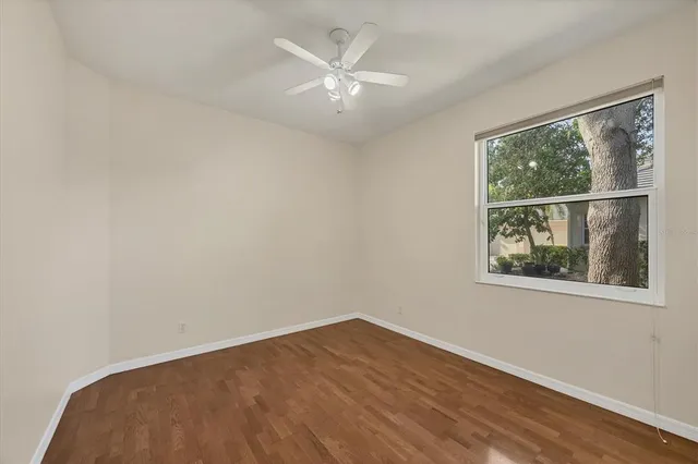an empty room with a window and a ceiling fan