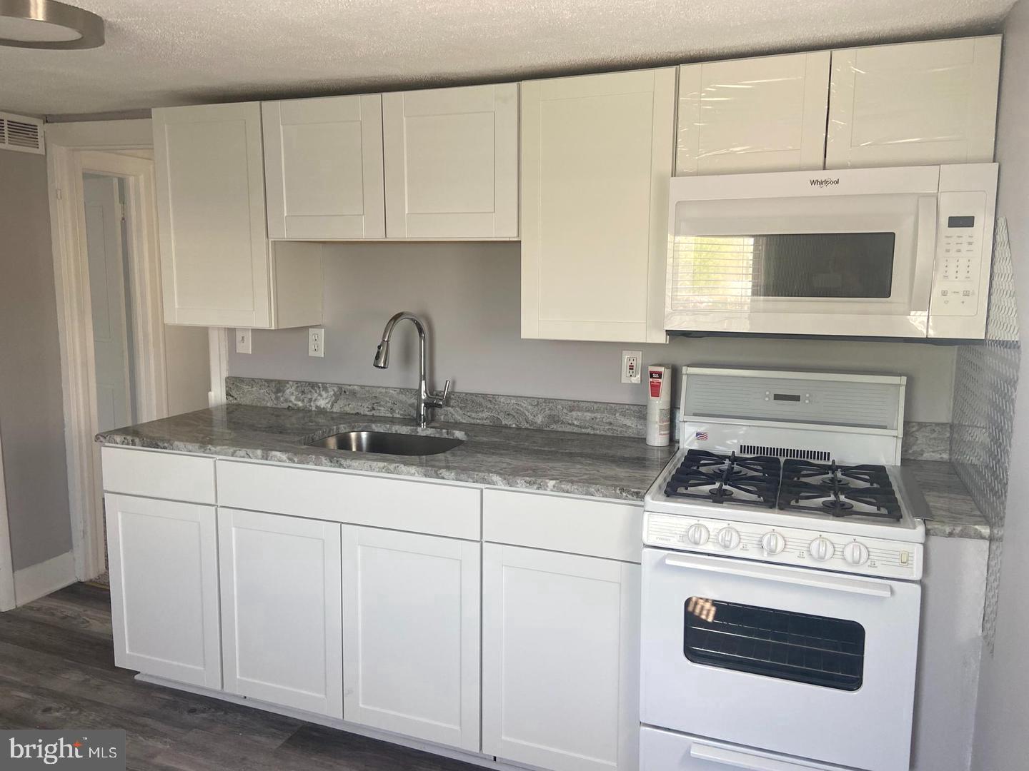 163 Klockner Road Trenton, NJ 08619 - Photo 6 of 22 a kitchen with granite countertop a stove sink and cabinets