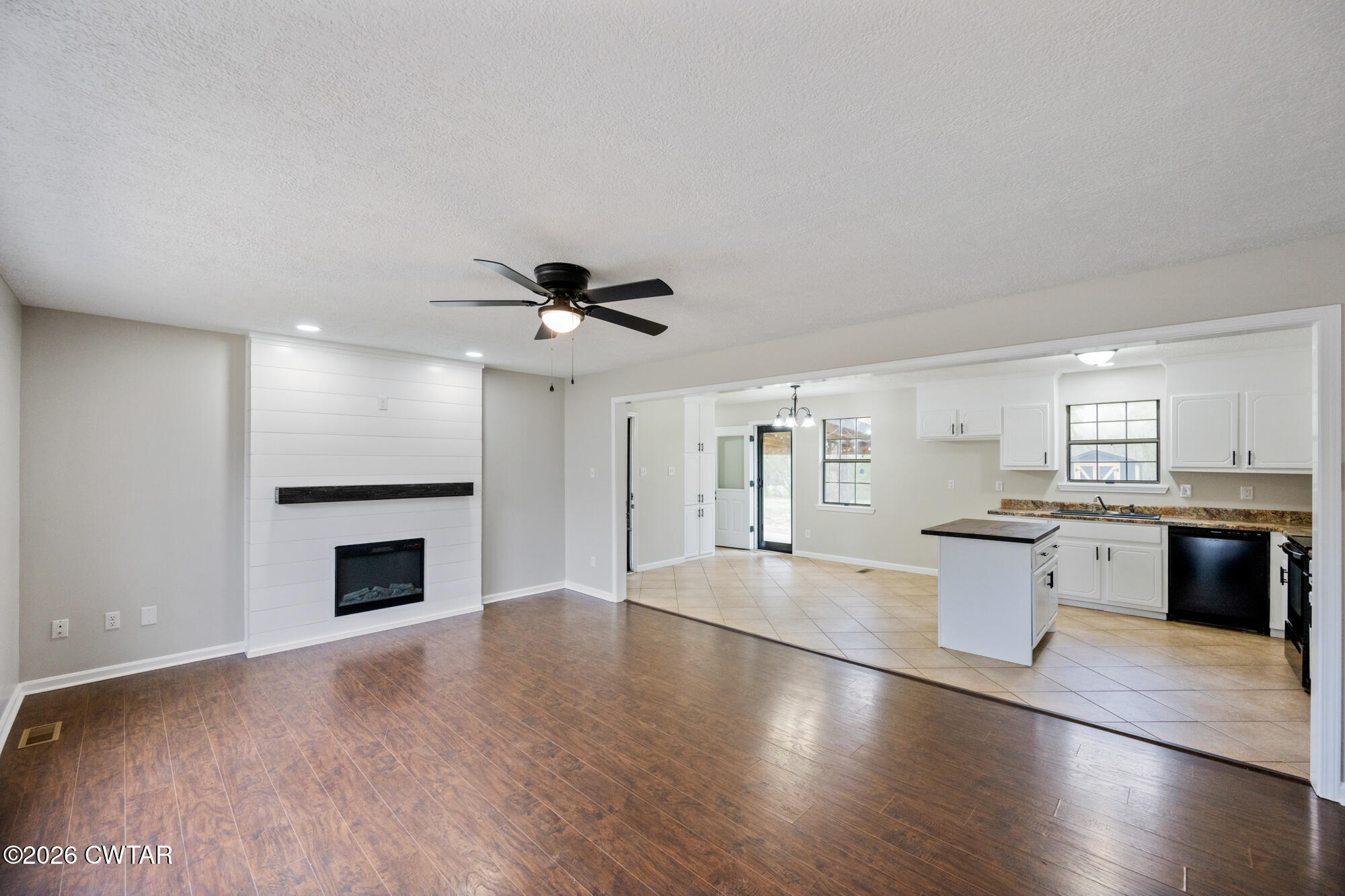 605 Parkburg Road Pinson, TN 38366 - Photo 5 of 15 a large kitchen with granite countertop a stove top oven a sink dishwasher a dining table and chairs with wooden floor
