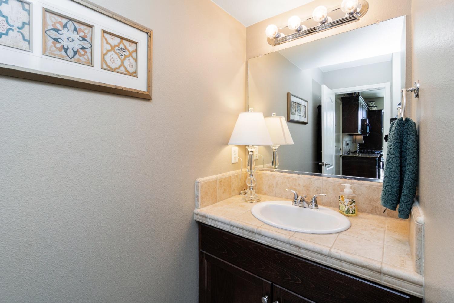 4103 Harlan Ranch Boulevard Clovis, CA 93619 - Photo 13 of 31 a bathroom with a granite countertop sink and a mirror