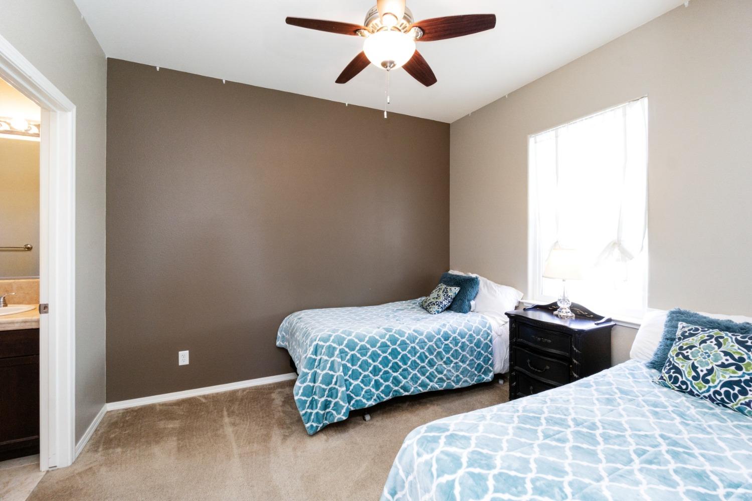 4103 Harlan Ranch Boulevard Clovis, CA 93619 - Photo 17 of 31 a bedroom with two beds and a chandelier