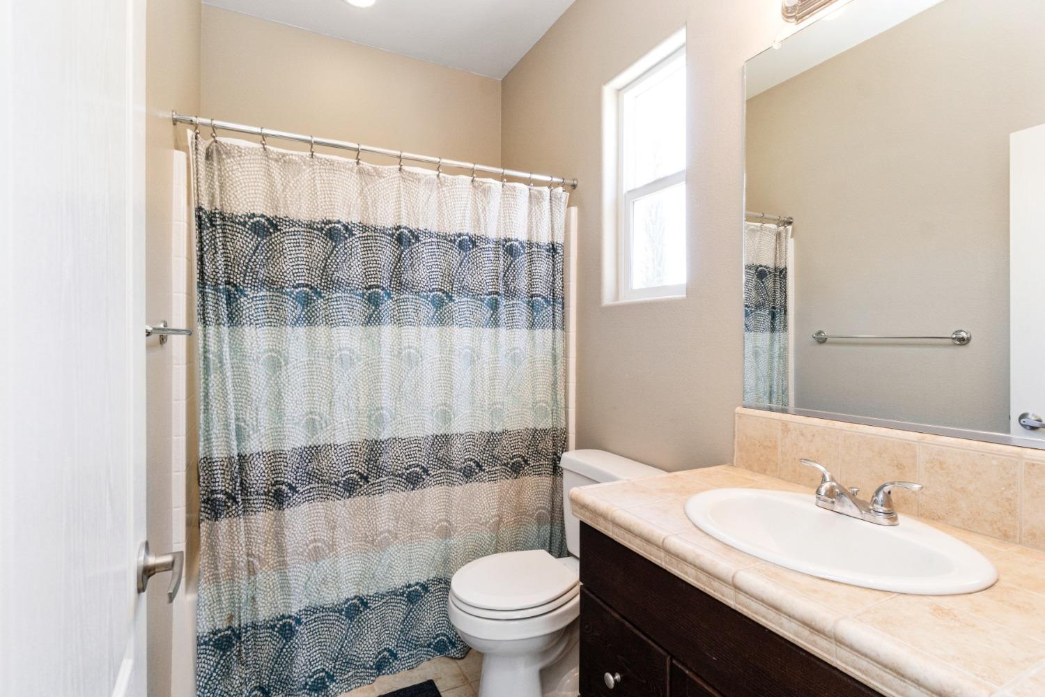 4103 Harlan Ranch Boulevard Clovis, CA 93619 - Photo 19 of 31 a bathroom with a granite countertop sink toilet and shower