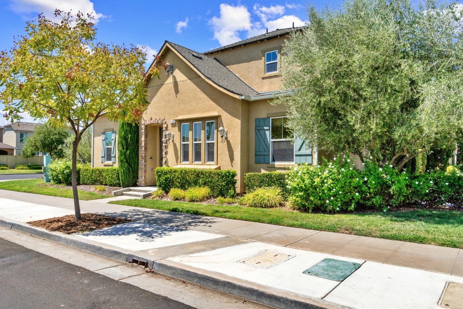 4103 Harlan Ranch Boulevard Clovis, CA 93619 - Photo 2 of 31 a front view of a house with a yard and trees