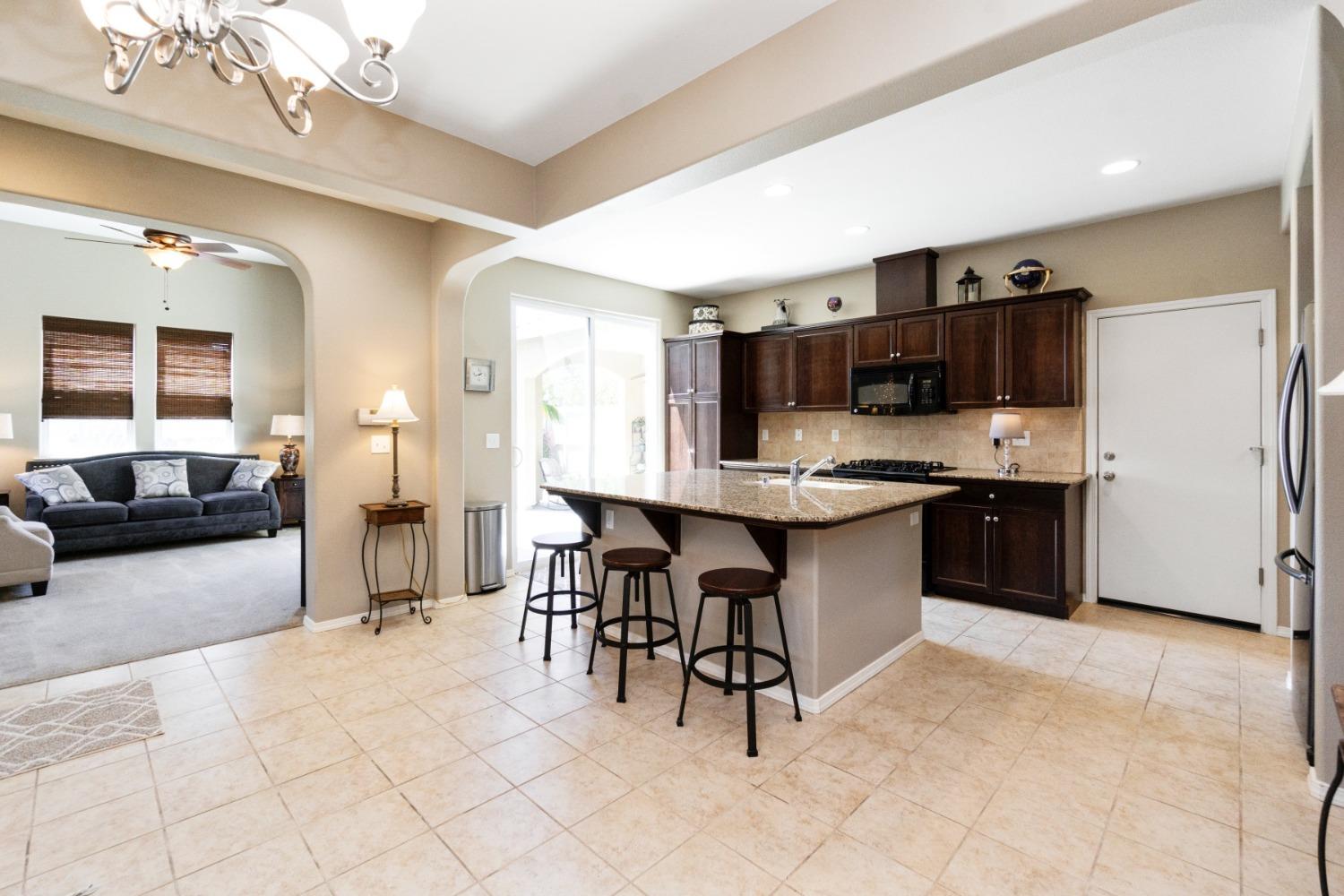 4103 Harlan Ranch Boulevard Clovis, CA 93619 - Photo 8 of 31 a large white kitchen with a large window and stainless steel appliances