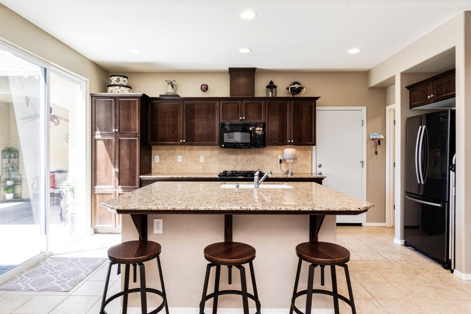 4103 Harlan Ranch Boulevard Clovis, CA 93619 - Photo 9 of 31 a kitchen with stainless steel appliances granite countertop a refrigerator and a stove top oven