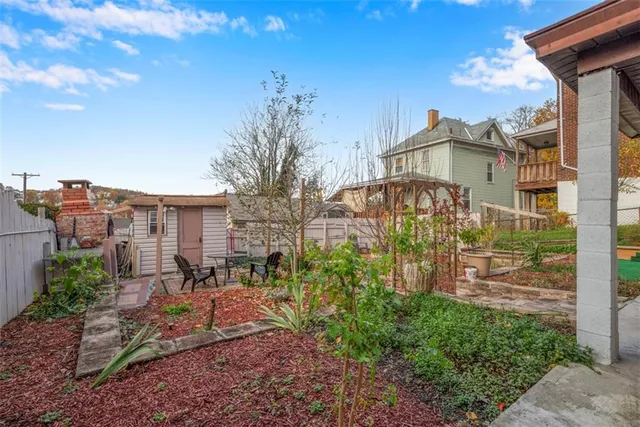 a view of a yard with plants and trees