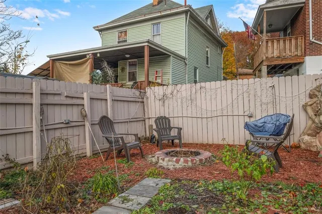 a backyard of a house with barbeque oven table and chairs