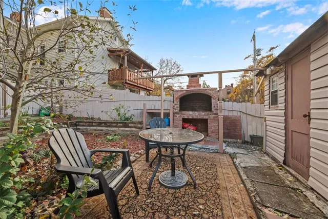 a view of a brick house with many windows next to a yard