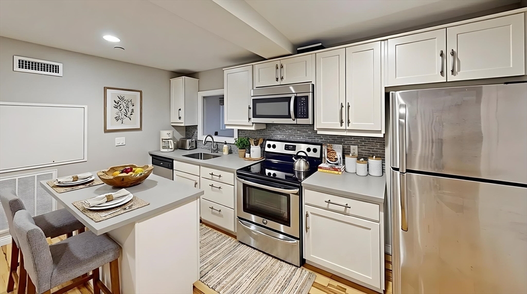 9 Anderson Street, Unit 1R Boston, MA 02114 - Photo 1 of 13 a kitchen with stainless steel appliances granite countertop a stove a refrigerator a sink a stove and white cabinets
