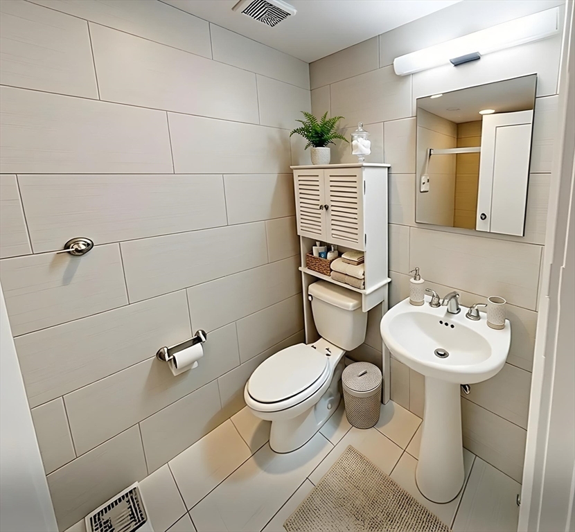 9 Anderson Street, Unit 1R Boston, MA 02114 - Photo 5 of 13 a bathroom with a toilet sink and mirror